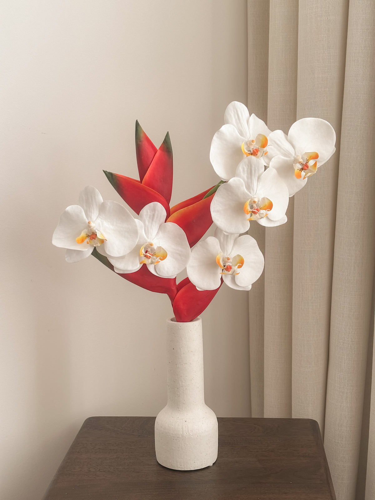 Faux white phalaenopsis orchid and red heliconia arrangement by FAUX Dubai
